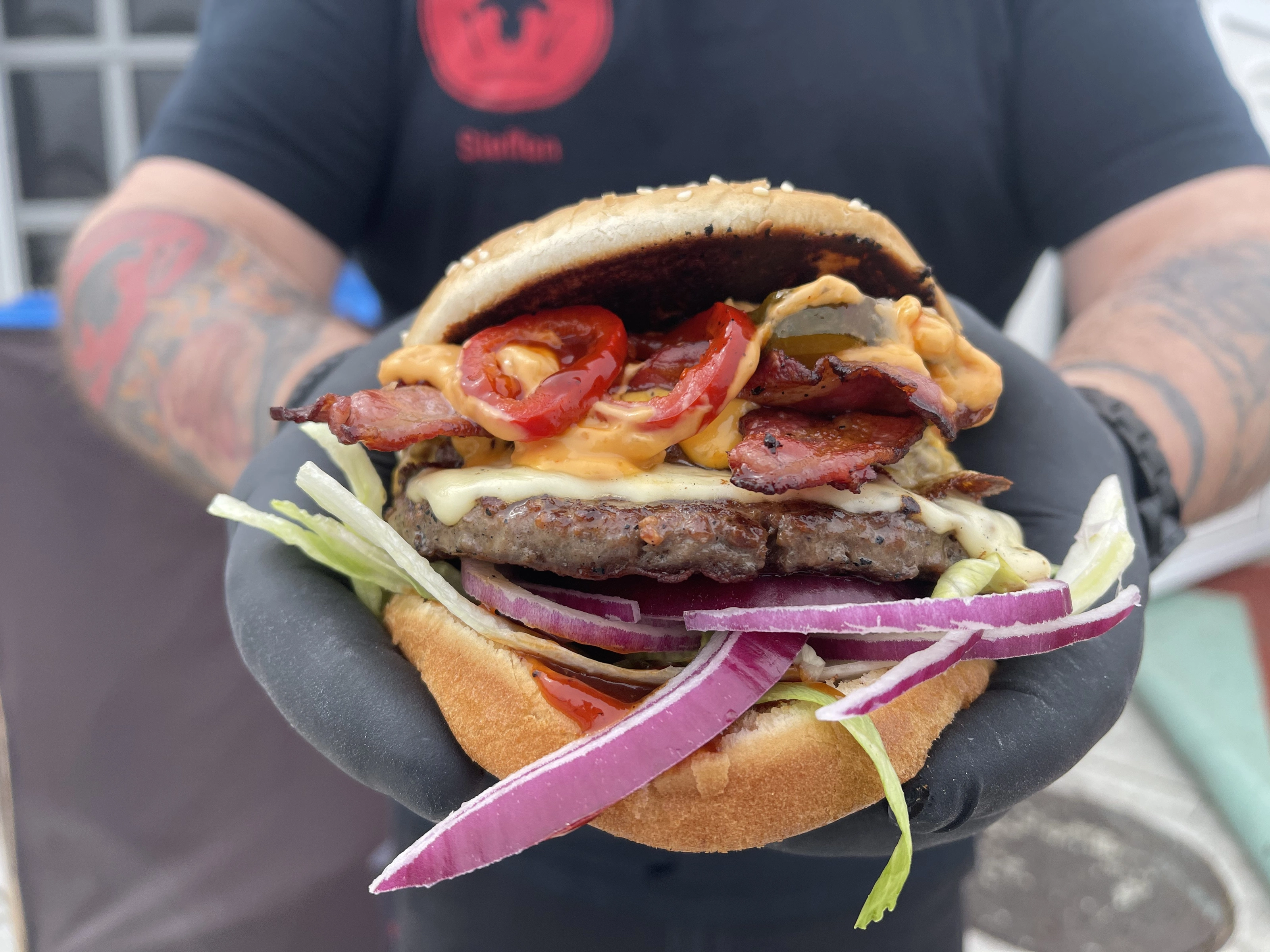 Frisch zubereiteter BBQ-Bulls Burger mit Bacon, Käse und roten Zwiebeln