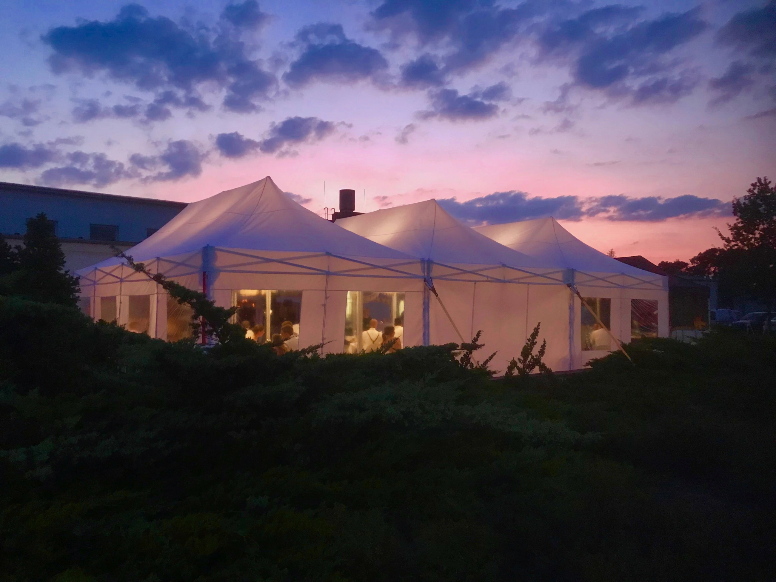 Beleuchtete weiße Pavillons auf der Terrasse im Sonnenuntergang