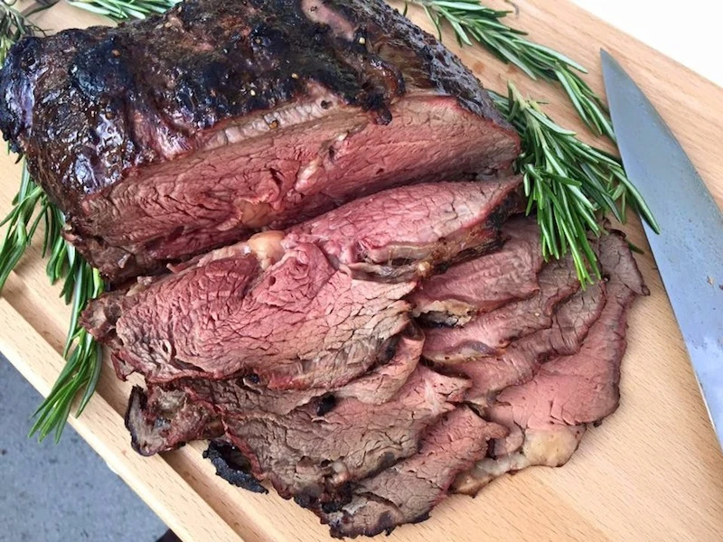 Aufgeschnittenes gegrilltes Fleisch mit rosa Kern auf einem Brett